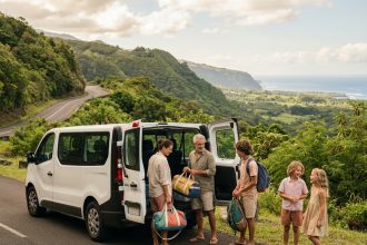 Famille nombreuse chargeant ses bagages dans un monospace 7 places blanc au bord d'une route tropicale à La Réunion
